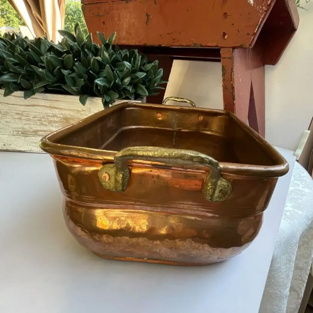 Antique hand-worked copper vessel visible dovetailed/soldered seam, hammered